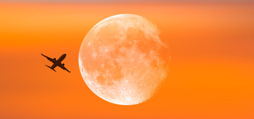 Airplane in the sky with full moon at sunset "Elements of this image furnished by NASA"