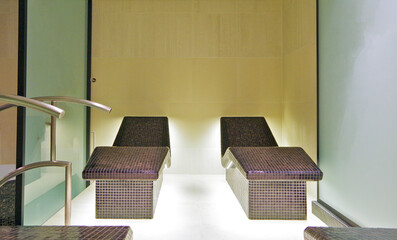 Thermal suite with heated loungers or relaxation chairs in spa or wellness area on modern luxury...
