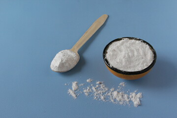 Collagen powder on blue background. Extra protein intake. Natural beauty and health supplement for skin, bones, joints and gut. Flatlay, top view. Copy space.