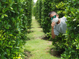 Portrait of a boy wearing black glasses And wearing a protective mask On a green background.