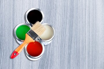 Different colorful paints in the metal can and brush