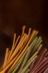Dry pasta of different colors, yellow with turmeric, pink with storm, green with spinach, Italian cuisine, telanatelle