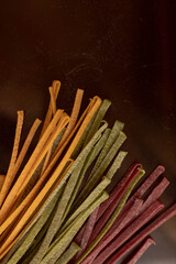 Dry pasta of different colors, yellow with turmeric, pink with storm, green with spinach, Italian cuisine, telanatelle
