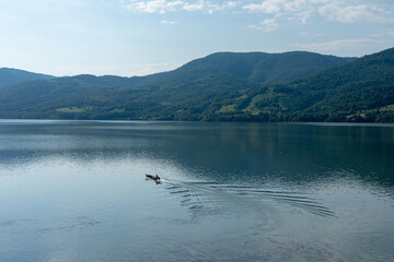 Fototapeta na wymiar fishing boat on the lake in the mountains in summer