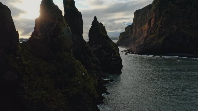 Aerial footage of troll toes rock formation on Reynisfjara black sand beach. Drone shot of crazy rock formation on the beach in Iceland.
