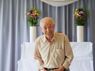 An elderly Asian man delivery a speech at a family event