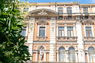 Facade of old architecture building with balconies and sculptures in sunny day, Luxury property, city trip