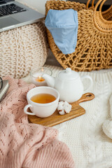 Laptop, face mask, hot tea mug, candle, glasses, kettle, wooden stand. Quarantine. Home Office. Cozy breakfast. Fall.