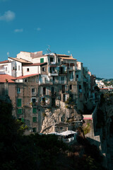 Fototapeta na wymiar View from above of the vintage buildings of the city center of Tropea, famous touristic destination in the south of italy. Sea view, old discarded buildings and homes.