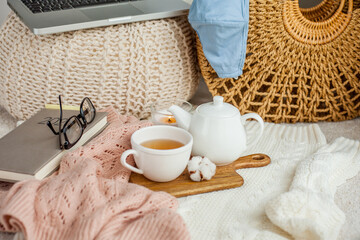 Laptop, face mask, hot tea mug, candle, glasses, kettle, wooden stand. Quarantine. Home Office. Cozy breakfast. Fall.