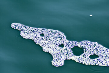 Obraz premium Biała piana na kolorowej wodzie.