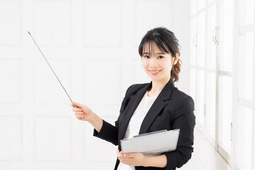 指し棒でポイントを示す若いビジネスウーマン