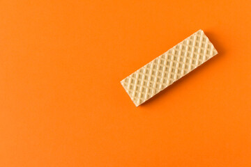 Waffle with chocolate on orange background. Selective focus.