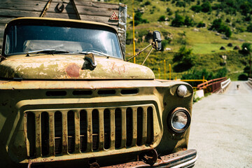 Fototapeta premium An old truck on a rural road.A battered truck is parked on an old paved road in a high-altitude area on a Sunny day