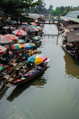 Fototapeta na wymiar Calm hour in one of Thailands floating market, boats filled with delicacy and colorful umbrellas protecting them from the sun.