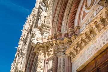 Lovely close-up view of a portal on the west façade of the Siena Cathedral in Italy. The portal,...