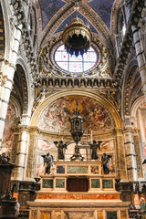 Obraz premium Wspaniały widok z bliska na marmurowy ołtarz główny z dużym brązowym tabernakulum eucharystycznym na prezbiterium słynnej katedry w Sienie. Ołtarz główny został zbudowany w 1532 roku przez Baldassarre Peruzzi.