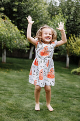 Little happy girl having fun in green summer park. happy chuldhood