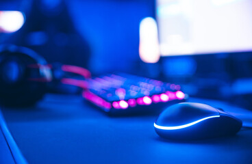 Computer gamer workplace for new game mouse and keyboard with blur pink neon light background © Parilov