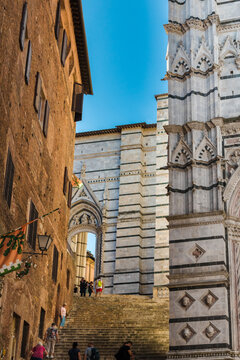 Nice view of a steep staircase leading to the side portal Porta laterale del Duomo Nuovo from Piazza San Giovanni; used as a passage between Piazza del Duomo and the street Via di Monna Agnese, Siena.