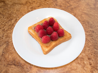 version of sweet sandwiches with raspberry berries and nut butter on a white plate. children's delicacy. school breakfast.