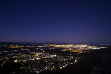 Beautiful cityscape view with city lights under a clear night sky © Ruben Bravo Matilla/Wirestock
