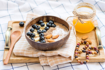 smoothie in a bowl of coconut with blueberries and banana
