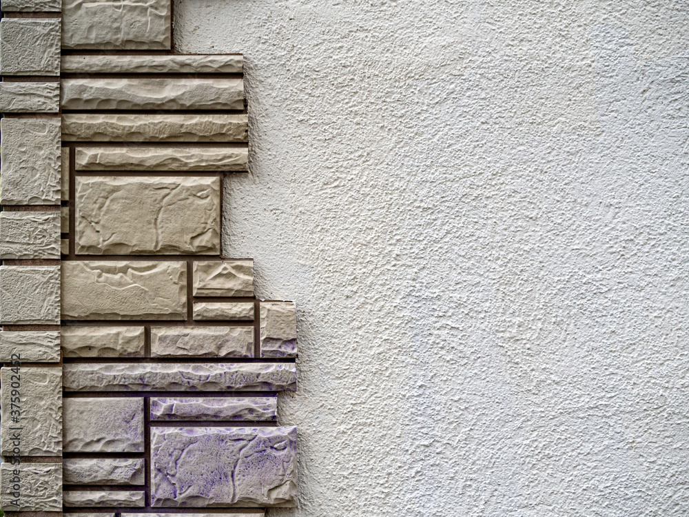 Poster on the left, a geometric pattern is laid out on a plastered wall made of decorative tiles of various