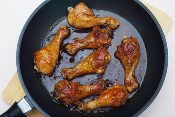 Fried chicken legs in a skillet. View of the home made food. Tasty coocked.