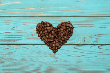 Background or wallpapper - heart made of coffee beans on wooden table