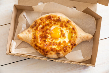 khachapuri adjara traditional Georgian cuisine meal. Baked bread with cheese and egg filling. National pastry snack. Free space concept