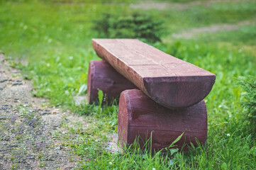 a log bench in the Park against a background of green grass.