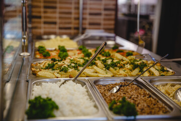 A variety of prepared dishes in containers in the dining room window. Public catering concept