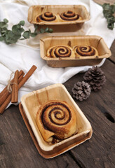 Cinnamon rolls on a plate from nature on a wooden table.