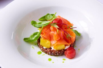 Delicate fillet of salmon on a cushion of quinoa with vegetables. Restaurant menu. White background. Free space for text.