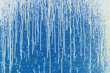 Spots, smears of paint on a blue metallic surface.