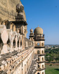 Beautifully carved exterior wall of Gol Ghumbaj with blue sky, Bijapur, India. © lalam