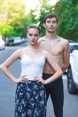 Portrait of a ballet couple on the street among cars