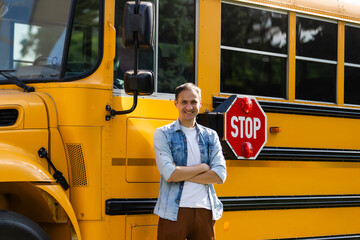 Smiling bus driver looking at camera outside the elementary school © Angelov