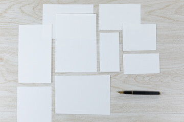 White sheet of papers and a pen on wood table