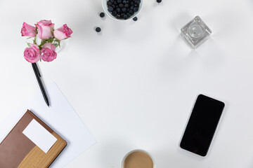 View of school supplies with flowers, phone and perfume on white background