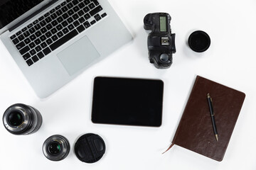 View of school supplies with a laptop and a tablet with a camera and lance in a white background