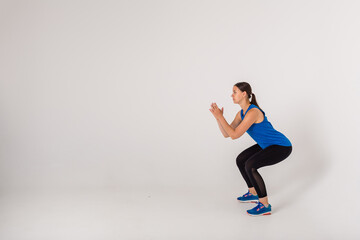 the sportswoman performs squats on a white background with space for text