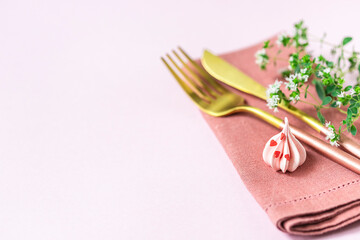 Pink meringue, knife and fork and linen napkin on a pink background. Celebration.