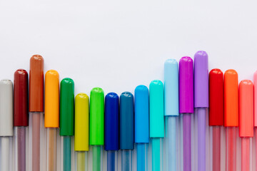 multi-colored markers on a white background