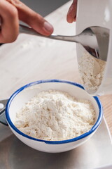 Meek pouring flour into a bowl