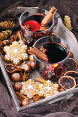 Christmas mulled red wine with addition cinnamon sticks, anise stars, cranberry and   oranges  in  glass  and gingerbread cookies 