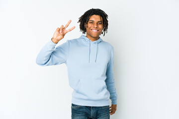Young african american rasta man joyful and carefree showing a peace symbol with fingers.