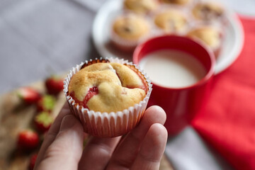 Homemade strawberry muffin in person hand