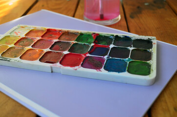 Multicolored palette of watercolor paints with brushes. Art, drawing.